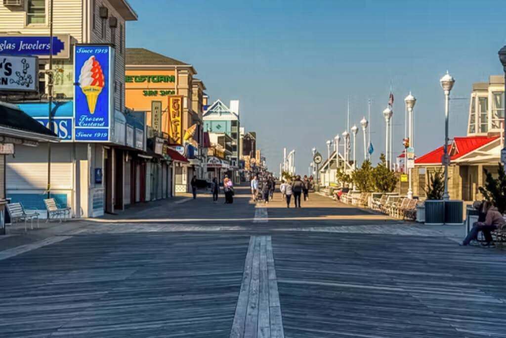 A boardwalk with shops, a clear sky, and a pedestrian walkway.
