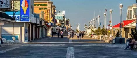 A boardwalk with shops, a clear sky, and a pedestrian walkway.