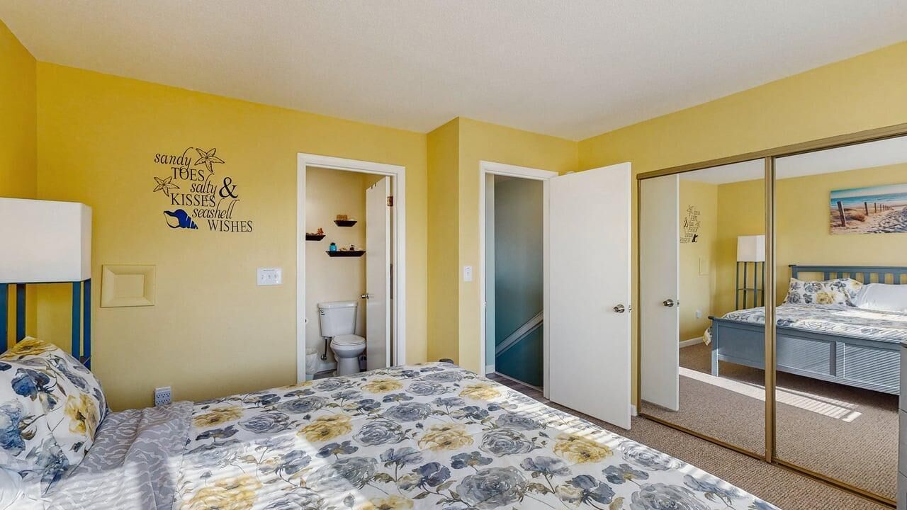 A bedroom with a bed, a toilet, and a shower area.