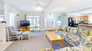 Ein Wohnzimmer mit Fernseher, Sofa und Couchtisch.