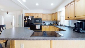 Eine moderne Küche mit Granit Arbeitsplatten, einem eingebauten Backofen, einer Mikrowelle und Holzschränken.