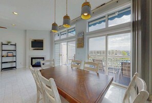 Ein Essbereich mit Holztisch und Stühlen, einem Kamin und großen Fenstern mit Blick auf die Stadt.