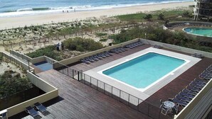 En pool på taket med utsikt över stranden och havet.