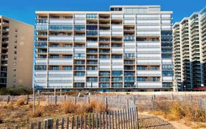Ein mehrstöckiges Wohngebäude mit modernem Design, mit Balkonen und großen Fenstern.