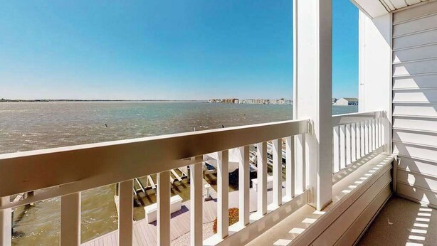Ein Balkon mit Blick auf das Meer und einen entfernten Steg.