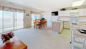 Eine moderne Wohnung mit Essbereich, Küche und großen Fenstern.