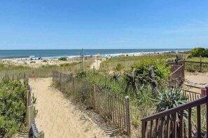 A sandy path leading to a beach with a wooden fence and a wooden staircase. - Irene 607 (Ocean City)