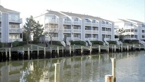 Ett hotell vid vattnet med flera balkonger, en brygga och ett lugnt vattenområde.