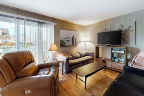 A living room with a sofa, a television, and a lamp. - Gullway Getaway (Ocean City)