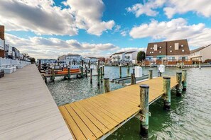A waterfront dock with boats, a wooden pier, and buildings along the water. - Gullway Getaway (Ocean City)