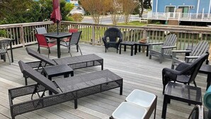 Una terraza con mobiliario exterior, incluyendo sillas y mesas, con vista a una zona residencial.