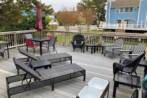 A deck with outdoor furniture, including chairs and tables, overlooking a residential area. - Canal-front home with boat dock, large deck, AC, washer/dryer & WiFi (Ocean City)