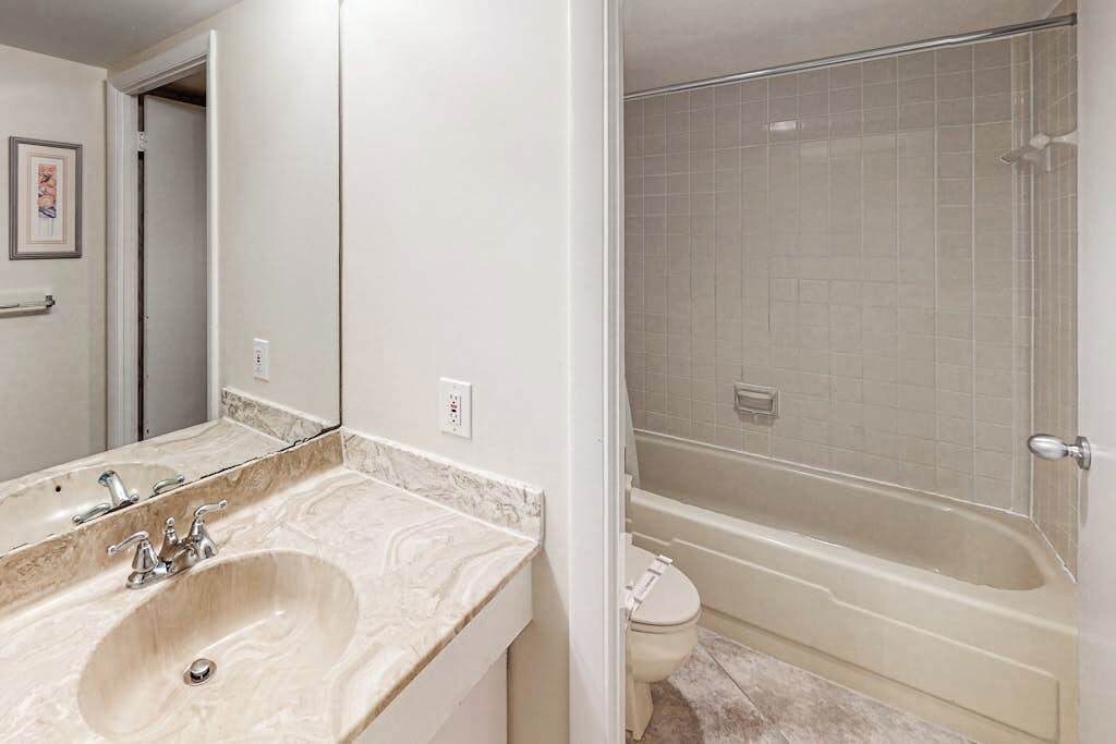 A bathroom with a sink, mirror, and shower.