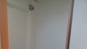 Une petite salle de bain étroite, avec un lavabo blanc, un miroir et une douche.