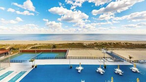 A rooftop pool with a view of the beach and ocean. - Waterfront condo with balcony, AC, tennis, pools & gym (Ocean City)