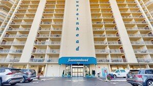 Ett hotell med flera våningar, med en stor, vertikal skylt i mitten där det står ”fountainhead 11604”.