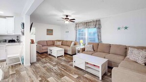 A modern living room with a sofa, coffee table, and a ceiling fan. - Endless Summer (Ocean City)