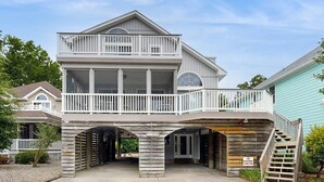 Ein zweistöckiges Haus mit Balkon, überdachter Eingangspforte und Schild für Feuerwehranschluss.