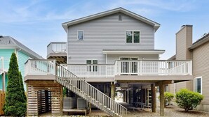 Ein zweistöckiges Haus mit einer Veranda und einer Treppe zu einer Terrasse.