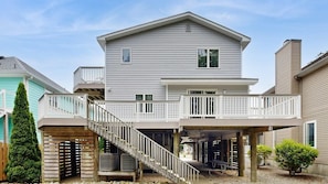 A two-story house with a covered patio and a staircase leading to a deck. - Donarum House 206 (Ocean City)