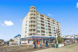 A multi-story hotel with balconies, a boardwalk in front, and a candy store. - Belmont Towers 708 (Ocean City)