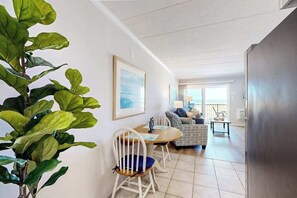 A modern living room with a dining area, a sofa, and a large plant. - Breakaway East 206 (Ocean City)