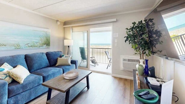 Ein modernes Wohnzimmer mit einer Couch, einem Couchtisch und einem Balkon mit Blick.