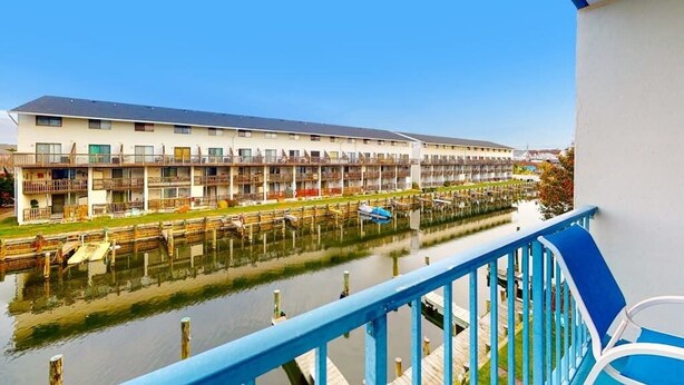 Ein Hotel am Wasser mit Balkonen, einem Steg und freiem Blick auf das Wasser.