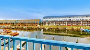 Ein Hotel direkt am Wasser mit mehreren Balkonen, einem Steg und freiem Blick auf das Wasser.