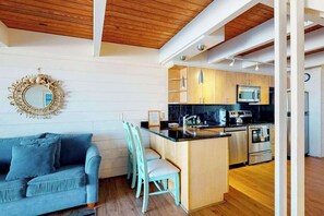 Eine moderne Küche mit Holzausstattung, Edelstahlgeräten und einer Bar.