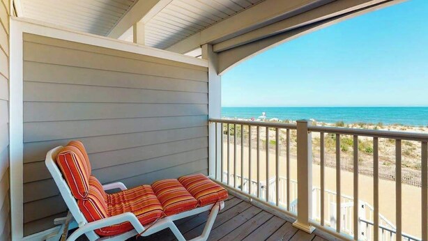 Un espacio de estar al aire libre techado con vistas a la playa.