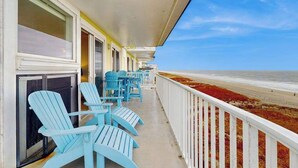 Ein Balkon mit Stühlen und Blick auf den Strand.