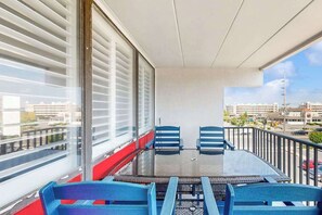 A balcony with a glass table and chairs, a view of the city, and a red railing. - Top-floor condo with balcony, walk 1 minute to the beach (Ocean City)