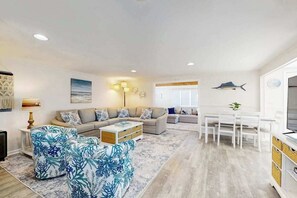 A modern living room with a sofa, coffee table, and dining area. - Belle Clair #1 (Ocean City)
