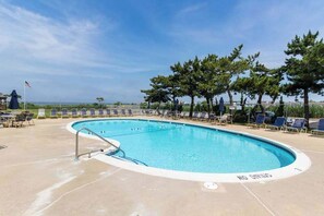 A swimming pool with lounge chairs and a flag. - Beach Club 109 B (Ocean City)