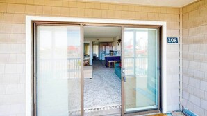 A residential entry with a sliding glass door, a visible kitchen area, and a number '208' on the wall.