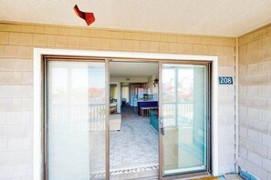 A residential entry with a sliding glass door, a visible kitchen area, and a number '208' on the wall. - Sea Mark 208 (Ocean City)