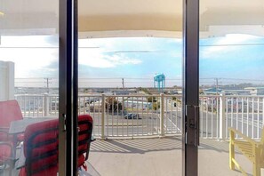 A balcony with a view of a parking lot and a water tower. - Updated, third-floor condo with balcony, W/D, central AC, & WiFi - near beach (Ocean City)