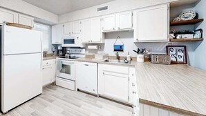 A kitchen with white cabinets, a microwave, a stove, and a dishwasher.