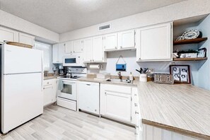 A kitchen with white cabinets, a microwave, a stove, and a dishwasher. - Bermuda Bay 9 (Ocean City)