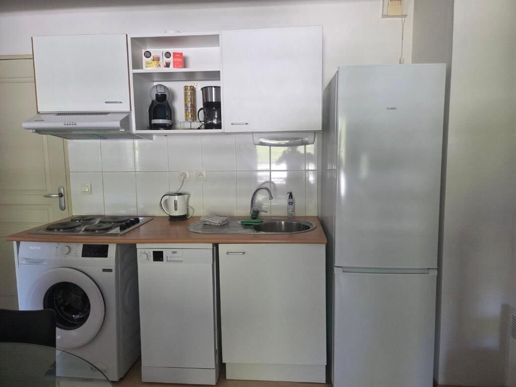 Eine kompakte Küche mit Waschmaschine, Geschirrspüler und Kühlschrank.