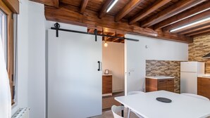 Una cocina moderna con protector mural de piedra, armarios de madera y un refrigerador blanco.