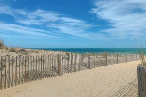 A sandy beach with a wooden fence and a clear blue sky. - Bayspot L-101 (Ocean City)
