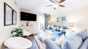 Ein Wohnzimmer mit einer Couch, einem Couchtisch und einem Deckenventilator.