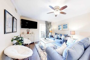 A living room with a sofa, coffee table, and a ceiling fan. - Bayspot L-101 (Ocean City)