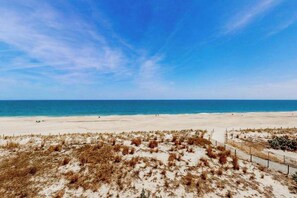 A beach with sand dunes and a clear blue sky. - Oceanfront Townhome w/ Multiple Decks, Amazing Views, W/D & Beach Access (Ocean City)
