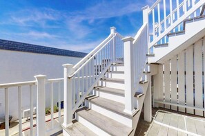 A white staircase with a railing, leading to a building with large windows. - Oceanfront Townhome w/ Multiple Decks, Amazing Views, W/D & Beach Access (Ocean City)