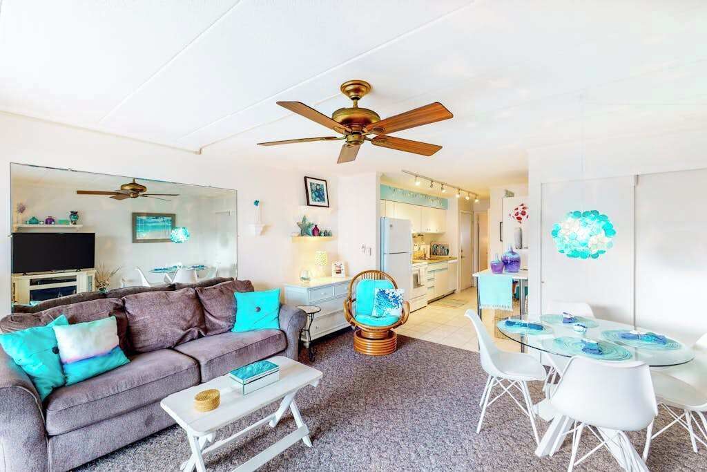 A living room with a sofa, coffee table, and a dining area with chairs and a table.
