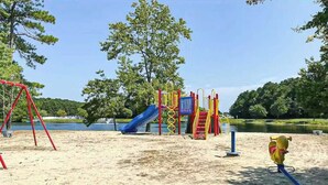 A playground with a slide, swings, and climbing structures. - Assateague Pointe - Bay View Beauty (Berlin)