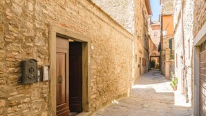 A narrow stone alleyway with a wooden door and a mailbox on the left. - Il Ponte - a romantic retreat blending history and panoramic views (Cortona)